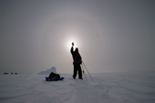 Ecotourist hold his hand in front of a sun halo. Weddell Sea. Antarctica.