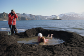 Bather in wooly hat in thermal pool at Whalers Cove. Deception Island. Antarctica