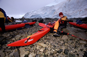 Preparing for a kayak trip on a beach below a glacier. Fastnet sea kayak. Antarctica