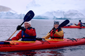 Happy tourists paddle a double kayak near Danko Island. Antarctica
