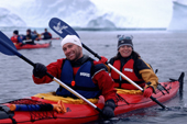 Happy tourists paddle a double kayak near Danko Island. Antarctica