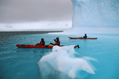 Eco tourists kayak over the sunk bit of an iceberg near Danco Island. Antarctica