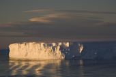 Iceberg and ripples on the Weddell Sea at sunset in October with lenticular clouds. Antarctica