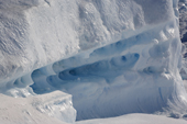 Detail of ice on the side of an iceberg showing holes in a softer layer of ice. Antarctica