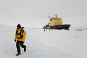 Russian Icebreaker Kapitan Khlebnikov parked in the sea ice in Antarctica with tourists walking around.