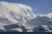 Cloud topped Mountain and katabatic winds blow over the lower glaciers. The Gerlache Strait. Antarctic Peninsular