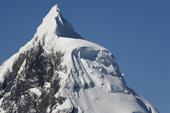 Mountain peak in Antarctica, draped with cornices and ice artifacts.