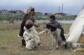 Young Chukchi in traditional fur clothing play with a dog. Yanrakynnot. Chukotka. Siberia. Russia. 1997