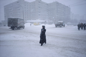 A woman walks in the centre of Murmansk during a winter snow storm. Kola Peninsula, NW Russia. 2005