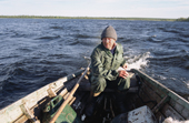 Sasha, a Sami man, stears his boat back to camp after checking his fishing nets near Lovozero (Strong Lake. Kola Peninsula, NW Russia. 2005