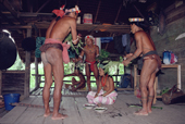 Mentawai medicine men treat a woman with tooth ache using herbs and shamanism. Siberut Island. Indonesia.
