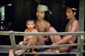 Mentawai men catch the breeze at the entrance of an Uma. Siberut Is. Indonesia.