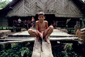 Mentawai boy in front of small house made of Sago Palm leaves and local woods. Matotonan, Siberut, Indonesia.