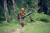 Mentawai woman returns with leaves she uses to cook sago in. Siberut Is. Indonesia.