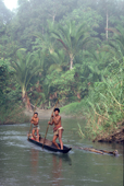 Mentawai men travel in a dugout canoe on the Rereiket river. Siberut, Indonesia.