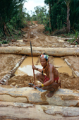 Mentawai medicine man on rainforest meranti logs. Siberut Island, Indonesia.