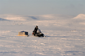 An Inuit hunter driving his snowmobile across the tundra during a hunting trip.George River, N.Quebec, Nunavik, Canada.