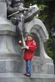 Girl touches the toe on the statue of Magellan's Indian in the Plaza Muoz Gamero, Punta Arenas. Chile.