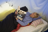 Visitor to Patriot Hills reads a book in her clamshell tent. Antarctica