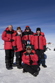 A group of visitors to the South Pole pose by the Ceremonial Pole. Antarctica