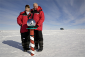 Connie & Martin Mandles pose by the reflecting globe at the Ceremonial South Pole. Antarctica