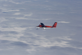 Twin Otter flies over the Polar Plateau, dappled with cloud shadows. Antarctica