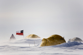 Mountain tents and the Chilean Flag in blowing Snow. Patriot Hills. Antarctica