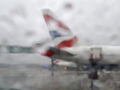 British Airways plane on the runway, seen through the rain on a window. Gatwick Airport. England