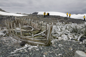 Tourists investigate the waterboat and whale bones at Mikkelsen Harbour, Trinity Island. Antarctica