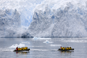 Two Zodiacs full of passengers cruise in front of a glacier in Cierva Cove, an inlet in mainland Antarctic Peninsula