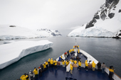 The Clipper Adventurer passes an iceberg in the Lemaire Channel on a grey day. Antarctica