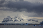 Booth Island illuminated with shafts of sunshine through the cloud. Lemaire Channel. Antarctica
