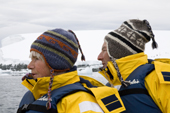 Mature tourists wearing warm hats in Antarctica