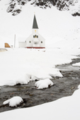 The stream cuts through the snow in front of Grytviken Church. South Georgia. Sub Antarctic Islands