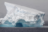 Tilted tabular iceberg with an ice cave. Antarctica