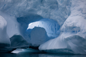 Ice arch in an iceberg in late evening light. Cierva Cove. Antarctica