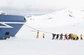 Passengers take turns to pull the hawser of the Ocean Nova on the ice at Deception Island. South Shetland Is. Antarctica