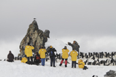 Tourists watch and film Chinstrap Penguins on Half Moon Island. Sth Shetland Is. Antarctica