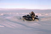 David Qaunaq, an Inuit hunter,drives snowscooter over snow covered sea ice near Igloolik, Nunavut, Canada. (1995)