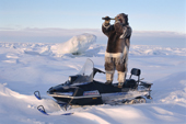 David Qaunaq, using a telescope to search for game while out hunting near Igloolik. Nunavut, Canada. (1995)