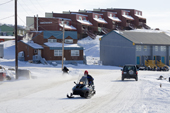 Cars and snowmobiles on the road below Stoneridge Apartments in Iqaluit. Nunavut. Canada. 2008