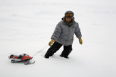 Aidan, an Inuit boy from Pangnirtung, plays out on the ice with a toy snowmobile. Nunavut, Canada. 2008