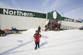 An Inuit boy and other shoppers outside the Northern Store in Pangnirtung. Nunavut, Canada. 2008