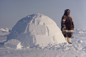 Thomasie Nutarariaq, an Inuk from Igloolik stands outside an Igloo. Nunavut, Canada. 1990