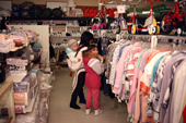 Inuit mother and girls shop for clothes in a shop at Igloolik, Nunavut, Canada. 1990