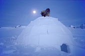 By moonlight, Aipilik, puts the finishing touches to an Igloo he has built. Igloolik, Nunavut, Canada. 1990