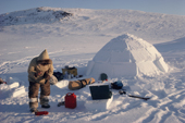 Aipilik, An Inuit hunter, refuels a Coleman stove at his camp. Igloolik, Nunavut, Canada. 1990