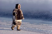 Inuit hunter dressed in furs walks along the floe edge. Igloolik, Nunavut, Canada. 1990