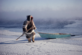 Louis Tepardjuk hauls up his floe edge boat while seal hunting at the ice edge. Igloolik, Nunavut, Canada. 1990