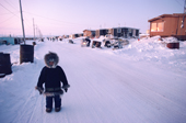 Inuit child wearing a fur trimmed parka, on the street in Baker Lake. Nunavut, Canada. 1982